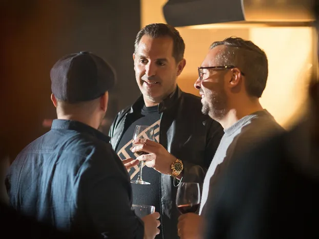 Three men chatting at event